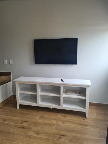 a white entertainment center with a flat screen tv on a wall at Casas de alto padrão em Condominio Privado in Chapada dos Guimarães