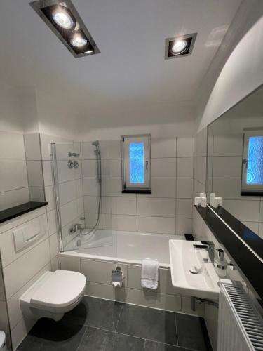 ein Badezimmer mit einem WC, einer Badewanne und einem Waschbecken in der Unterkunft SUITE APART direkt am Bahnhof in Eisenach