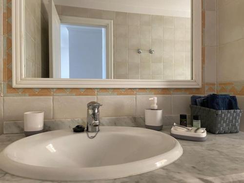 Amazing Penthouse في لوس كريستيانوس: بالوعة بيضاء في الحمام مع مرآة