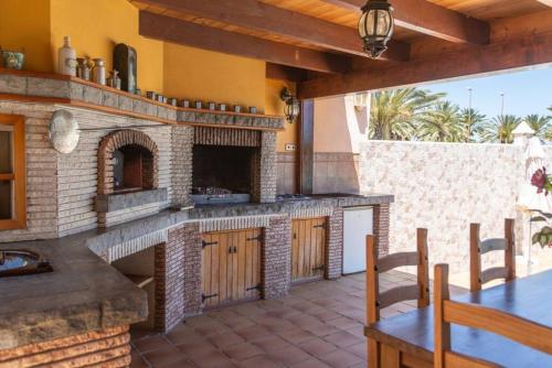 an outdoor kitchen with a brick oven in a house at Caleta de Fuste Villa Vergel with Huge Private Pool, Jacuzzi, & BBQ by Amazzzing Travel in Caleta De Fuste