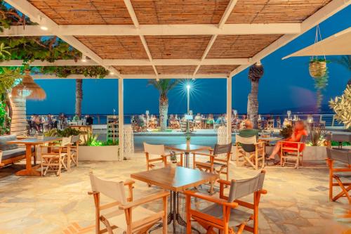 a restaurant with tables and chairs and a pool at Maistrali Sea View Apartments in Stalida