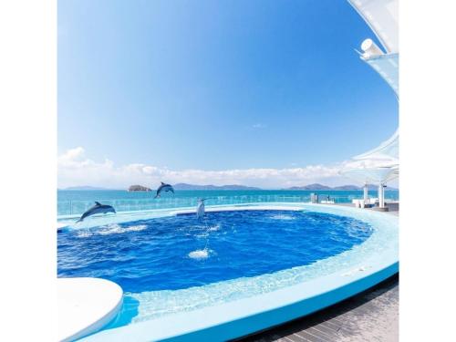 a pool with dolphins jumping in the water at Zentsuji Grand Hotel - Vacation STAY 16629v in Zentsuji