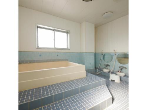 a bathroom with a tub and a toilet and a sink at Zentsuji Grand Hotel - Vacation STAY 16635v in Zentsuji