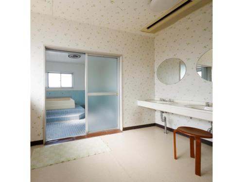 uma casa de banho com um chuveiro, um lavatório e um espelho. em Zentsuji Grand Hotel - Vacation STAY 16635v em Zentsuji