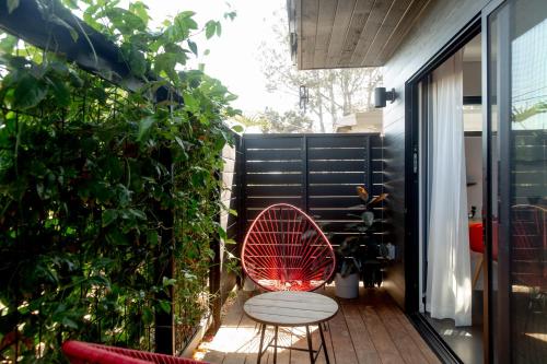 a small balcony with a red chair on a patio at Twelve Senses Retreat, a Member of Design Hotels in Encinitas