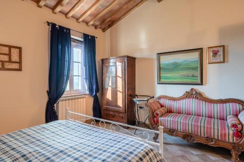 um quarto com uma cama, um sofá e uma janela em Villa Petri em Uzzano