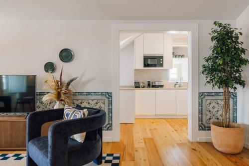 a living room with a chair and a kitchen at Ando Living - Madalena House in Lisbon