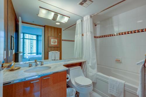 a bathroom with a toilet and a sink and a mirror at Dunowen Properties in Vancouver