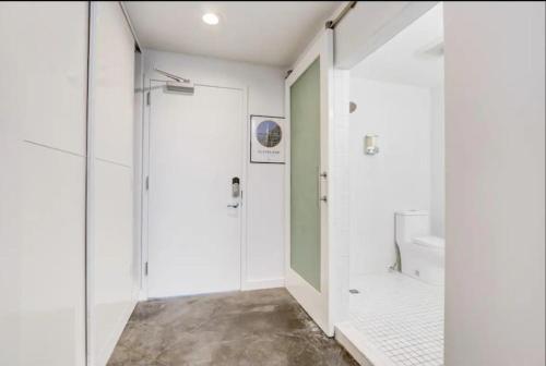 a white bathroom with a shower and a toilet at KCM Mikros Smart Apartments 7 in Cleveland