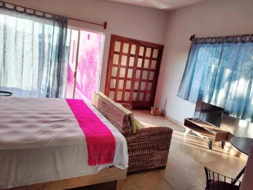 a bedroom with a bed with a pink blanket on it at Estudio con aroma a Oaxaca in Tangolunda