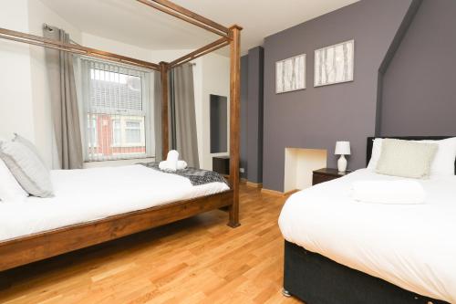 1 dormitorio con 2 camas y ventana en Charming 3 bed house near Liverpool stadium 10 mins drive to city centre en Liverpool