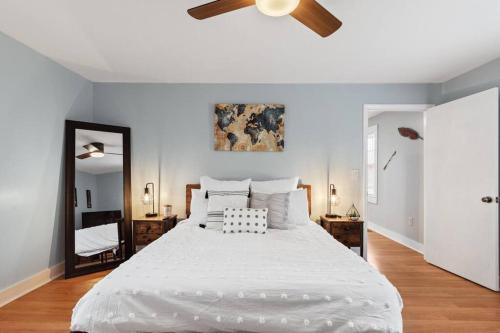 - une chambre avec un grand lit blanc et un ventilateur de plafond dans l'établissement BOHO BUNGALOW - STEPS FROM HISTORIC DOWNTOWN APEX, à Apex