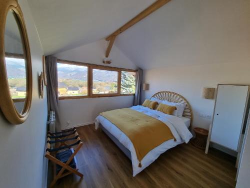 ein Schlafzimmer mit einem Bett und einem großen Fenster in der Unterkunft Appartement 4 personnes Lac d'Annecy in Lathuile
