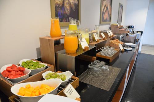 a buffet line with fruits and vegetables and orange juice at DM Hoteles Moquegua in Moquegua