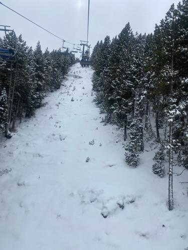 a snow covered ski slope with trees and a ski lift at Piso en el port del comte in La Coma i la Pedra