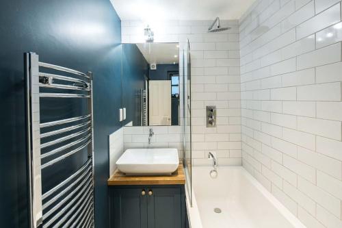 a bathroom with a sink and a tub and a bath tub at Superb Retreat Central Next Tube in London