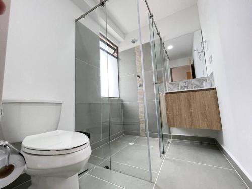 a bathroom with a toilet and a glass shower at Conjunto Amuray -Cómoda casa cerca al aeropuerto in La Tebaida