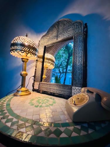 a table with a mirror and a lamp on it at Riad Al Nour in Marrakech