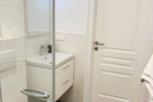 uma casa de banho branca com um lavatório e um espelho em Cozy and stylish flat close to Schoenbrunn Palace em Viena