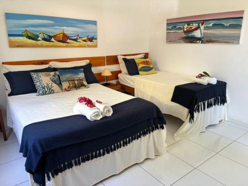 a room with two beds with towels on them at Pousada Cacau e Dendê in Barra Grande