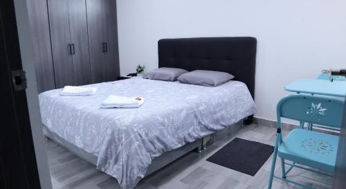 a bedroom with a bed with two towels on it at TOCANCIPÁ, Increíble, Hermoso y Moderno APARTAMENTO COMPLETO! in Tocancipá