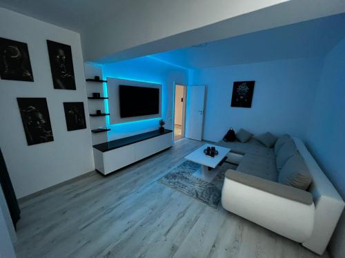- un salon avec un canapé et une télévision dans l'établissement Amelia Apartment, à Braşov