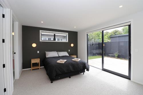 a bedroom with a bed and a large window at Urban Cube in Invercargill