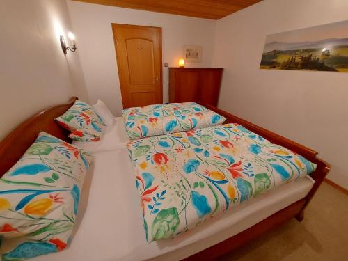 una camera da letto con un letto con un piumone e cuscini di Ferienwohnung Grünwald a Grünwald