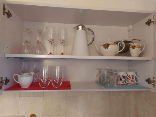 a shelf with wine glasses and other items on it at Ferienwohnung Grünwald in Grünwald