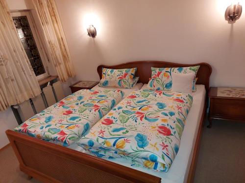 a bedroom with a bed with a floral comforter at Ferienwohnung Grünwald in Grünwald