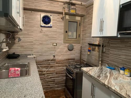 a small kitchen with a stove and a sink at 3-Bedroom Apartment with Stunning Sea-Side View in Alexandria