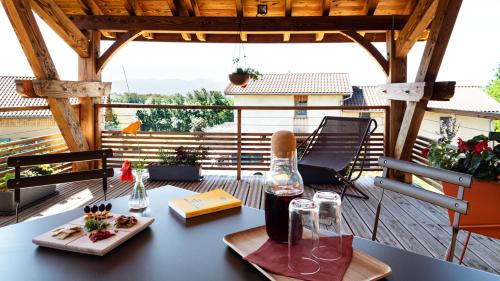 a table with a bottle of wine on a balcony at Graine de Tilia in Saint-Antoine