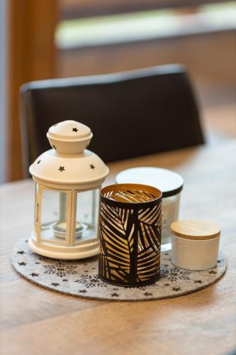 a table with a lantern and cups on it at Casa Fochin tra Bormio e Livigno in Valdidentro