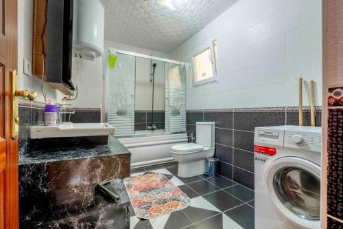 y baño con lavamanos y lavadora. en Bakirköyde Saray Dairesi, en Estambul
