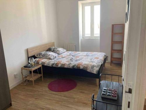 een kleine slaapkamer met een bed en een tafel bij Escapade dans le Golfe du Morbihan - T2 3ème étage in Auray