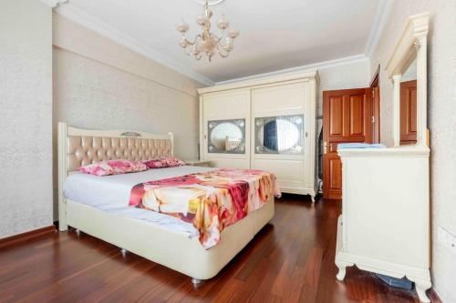 a bedroom with a white bed and a chandelier at Bakirköyde Saray Dairesi in Istanbul