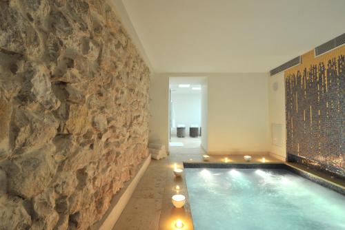 a swimming pool in a room with a stone wall at La Maison d'Aix in Aix-en-Provence
