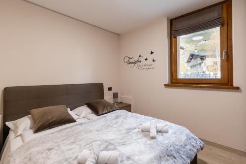 a bedroom with a bed with two towels on it at Casa Fochin tra Bormio e Livigno in Valdidentro