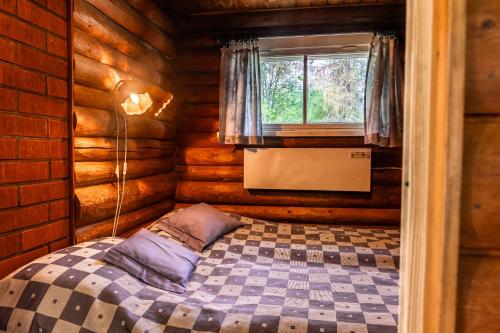 ein Schlafzimmer mit einem Bett in einem Blockhaus in der Unterkunft Aamun Kajo in Kuusamo