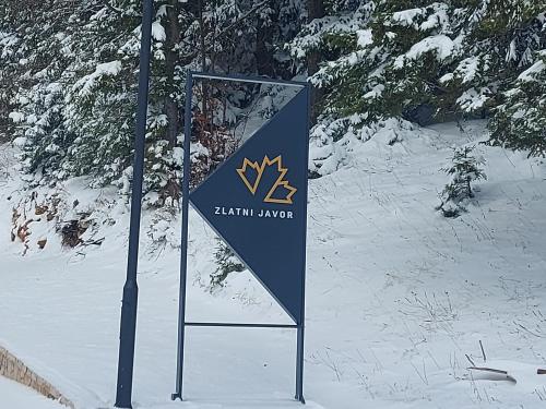 um sinal na neve ao lado de um poste em Apart Hotel Zlatni Javor, Apartment 410 em Jahorina