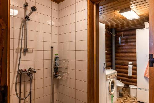 a bathroom with a shower and a washing machine at Aamun Kajo in Kuusamo