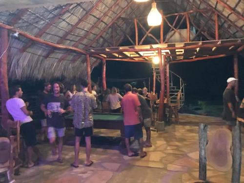 a group of people standing around a pool table at Castaways Nicaragua in Popoyo