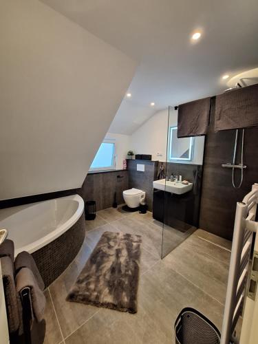 ein Badezimmer mit einer Badewanne, einem WC und einem Waschbecken in der Unterkunft Ferienhaus Aycu in Bremen