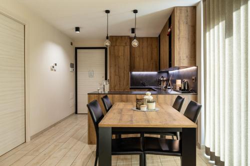 a kitchen with a wooden table and chairs at Casa Fochin tra Bormio e Livigno in Valdidentro
