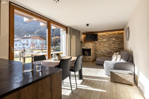 a kitchen and living room with a table and chairs at Casa Fochin tra Bormio e Livigno in Valdidentro