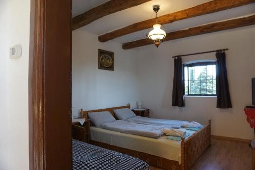 a bedroom with a bed and a window and a mirror at Joe Bácsi Rezidenciája in Kisharsány