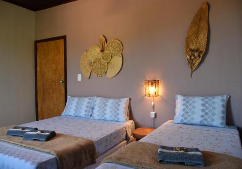 a bedroom with two beds and a lightswitch on the wall at Serra Grisante Pousada Bed and Breakfast in Lençóis