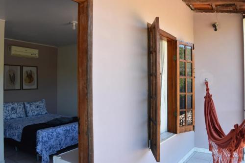 a room with a mirror and a bed and a window at Pousada Serra Grisante in Lençóis