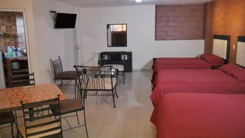 a room with two beds and a table and a dining room at Hotel Dubai de Miramar in San Blas