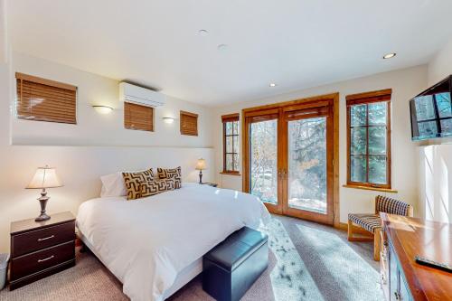 a bedroom with a bed and a desk and windows at Silver King in Aspen